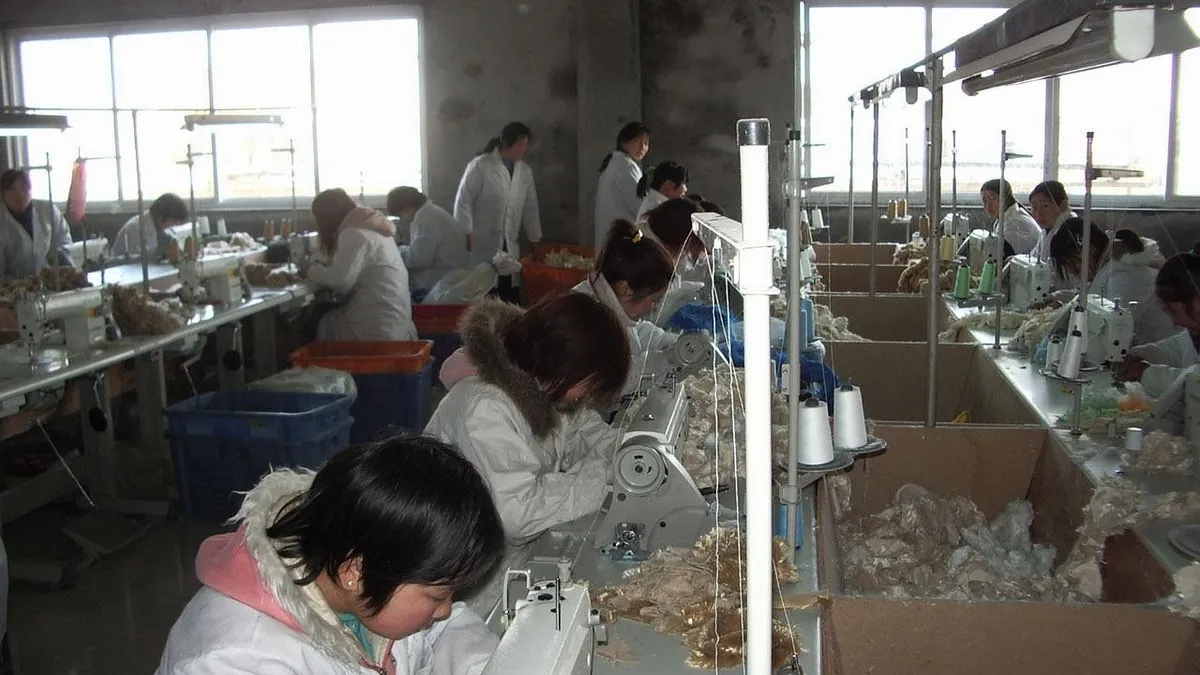 Workers at sewing machines on a factory production floor